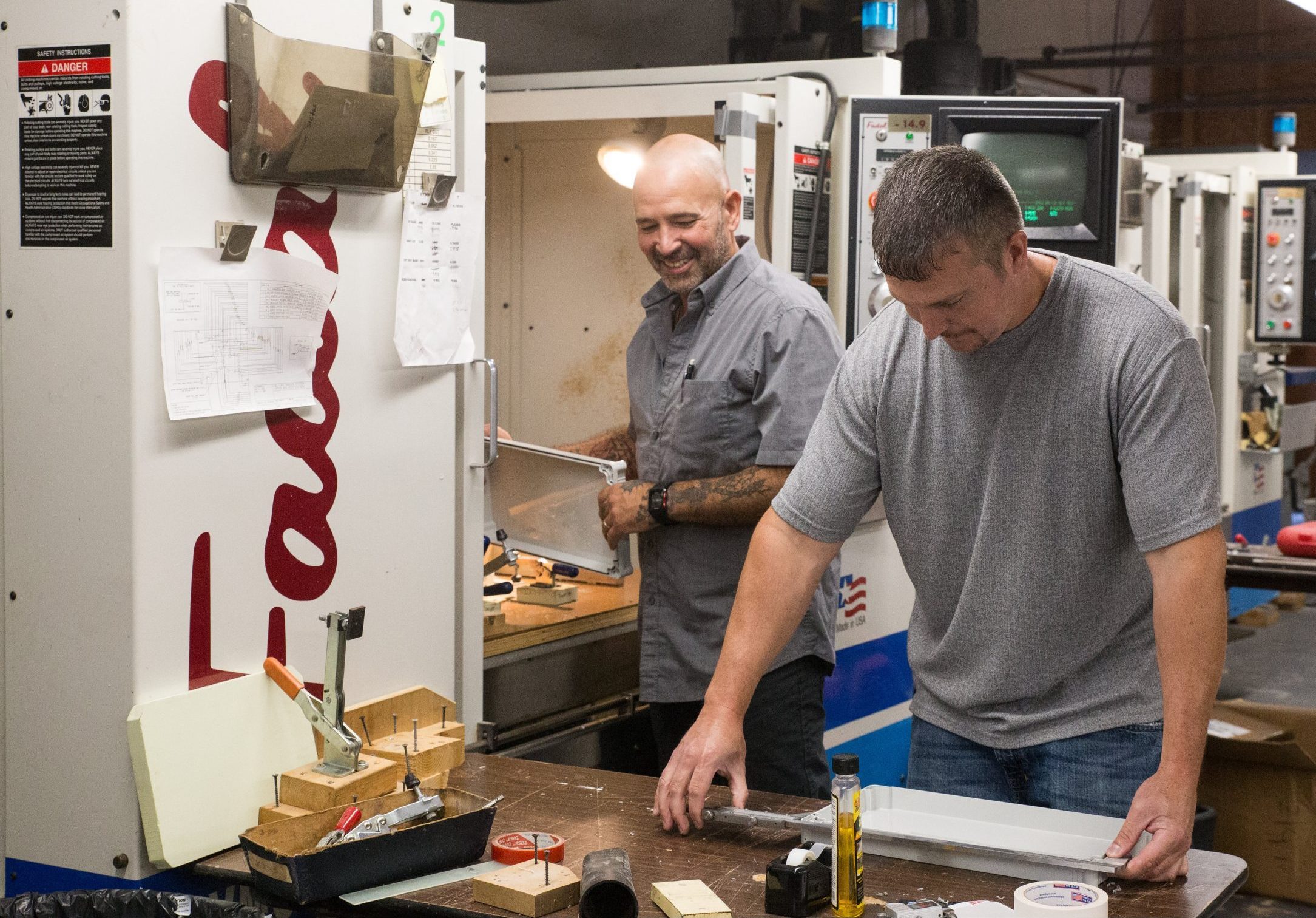 Two American Micro Industries employees at work.