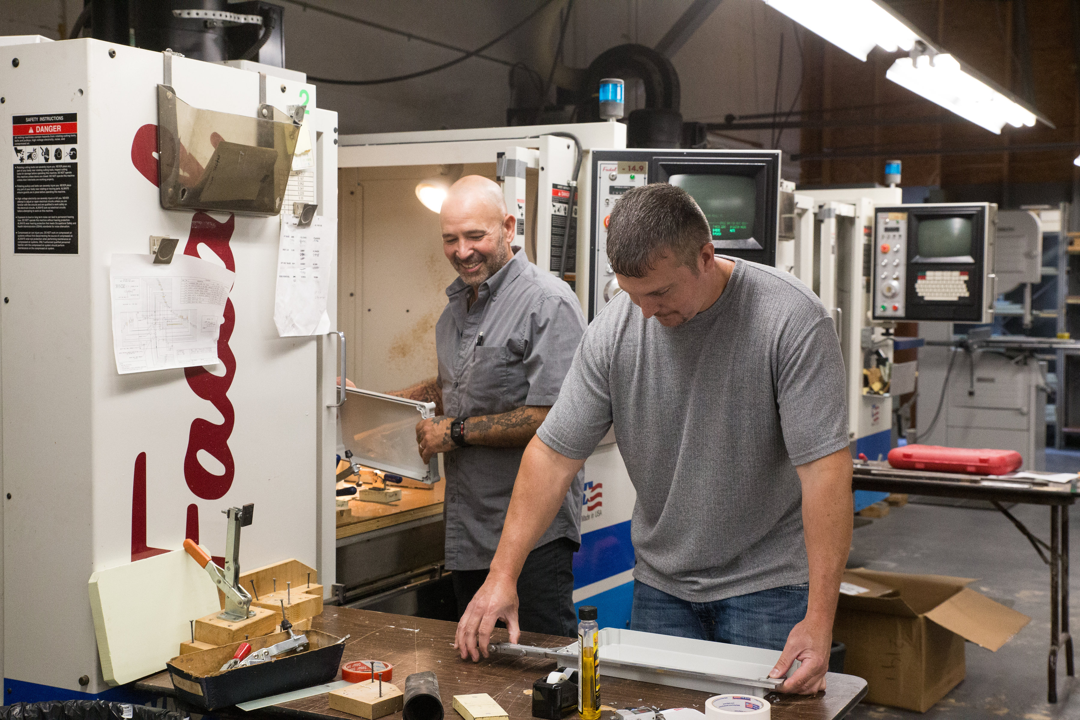 Two American Micro Industries employees at work.